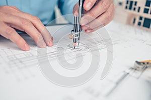 Architect engineer use compass drawing design working on blueprint. House planning design and construction concept