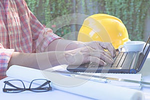 Architect engineer using laptop for working with white helmet,