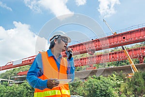 Architect or Engineer, wearing white Hardhat and safety vest, us