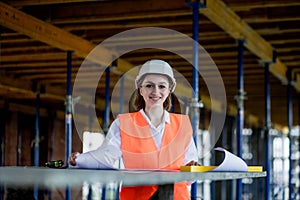 Architect or engineer working, browsing building project indoor of construction site with blueprint plan. Woman