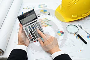 Architect or engineer working project accounting with graph with tools in office, Construction account.