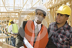 Architect With Foreman Inspecting Framework