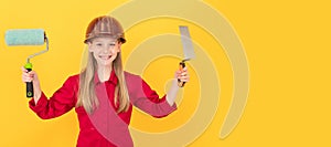 Architect girl. smiling teen child in builder hard hat with paint roller and spatula on yellow wall. Child builder in