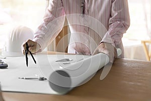 architect hand holding compass working on construction project