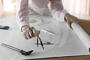 architect hand holding compass working on construction project