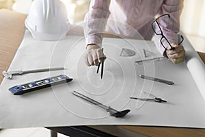 architect hand holding compass working on construction project