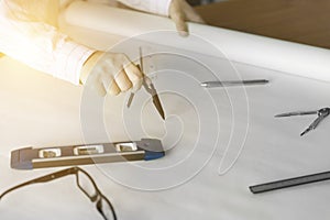 architect hand holding compass working on construction project