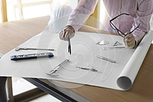 architect hand holding compass working on construction project