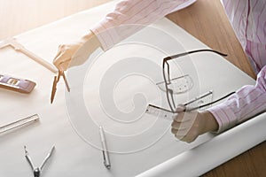 architect hand holding compass working on construction project