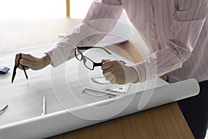 architect hand holding compass working on construction project