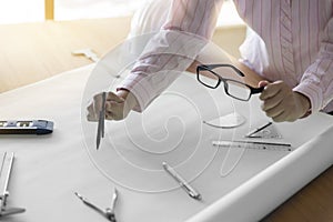 architect hand holding compass working on construction project