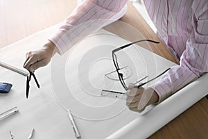 architect hand holding compass working on construction project