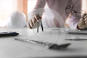 architect hand holding compass working on construction project