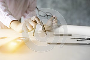 architect hand holding compass working on construction project