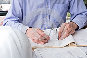 Architect hand holding drawing compass working on construction p