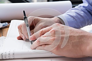 Architect hand holding drawing compass working on construction p