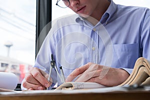 Architect hand holding drawing compass working on construction p