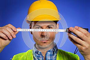 Architect in hardhat holding tape measure