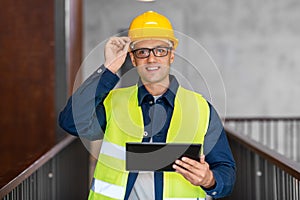 architect in helmet and safety west with tablet pc