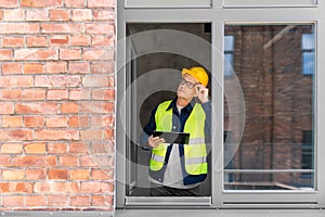 architect in helmet and safety west with tablet pc