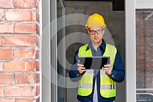 architect in helmet and safety west with tablet pc