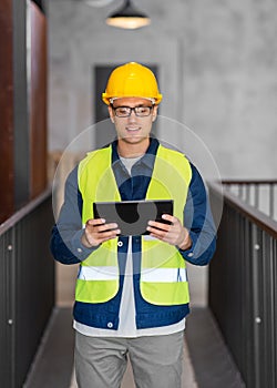 architect in helmet and safety west with tablet pc
