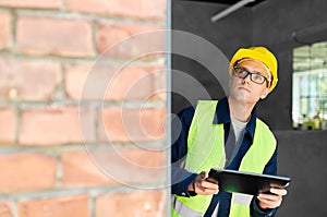 architect in helmet and safety west with tablet pc