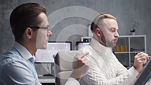 Architect and his colleague work in loft using drawing board and computers. Workplace of civil engineer in modern office