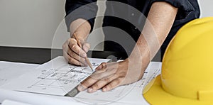 An architect, a home design engineer, is drafting a house plan for a client in his office.