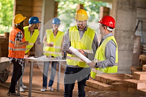 Architect and investiture handshaking on construction site