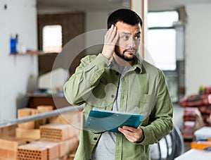 Architect making notes on indoor construction site