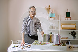 Architect man or designer working with building model in office