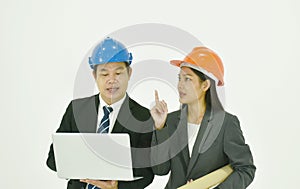 Architect man and woman wearing colorful helmet diccusing for work in whitre background