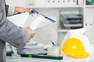 Architect in office keeping keys in the hand