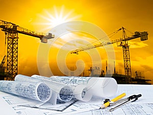 Architect plan on working table with crane and building construction background