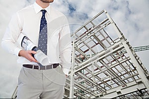 Architect with plans standing on in construction site