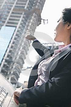 Architect pointing at building at a construction site