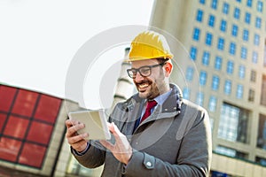 Architect in protective helmet using digital tablet