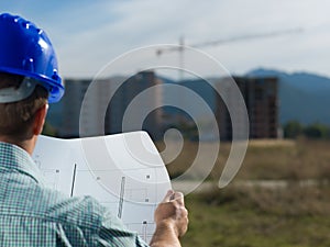 Architect reading technical drawing of construction