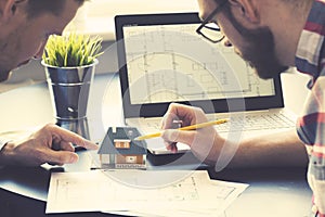 Architect showing new house model to customer at office