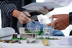 Architect Student Discussion and Meeting About Home Design with Paper Model of Modern House Miniature Sample of Architect Student