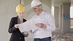 Architect team man and woman discussing about building plan for construction at job site