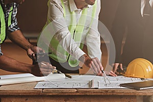 Architect team working with blueprints for architectural plan, engineer sketching a construction project, green energy