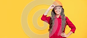 Architect teenager girl. kid future engineer on yellow background. safety glasses for repairing. Child builder in helmet