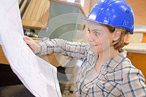 Architect woman with helmet and plans