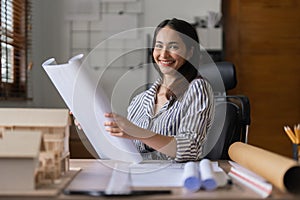 Architect woman working with blueprints for architectural plan, engineer sketching a construction project, green energy