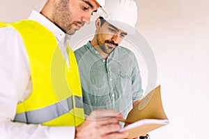 Architect worker discussing with contractor male at construction building site