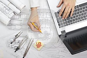 Architect working on blueprint. Architects workplace - architectural project, blueprints, ruler, calculator, laptop and