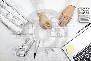 Architect working on blueprint. Architects workplace - architectural project, blueprints, ruler, calculator, laptop and