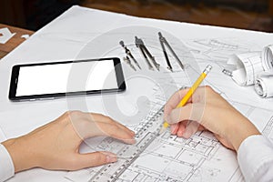 Architect working on blueprint. Architects workplace - architectural project, blueprints, ruler, calculator, laptop and